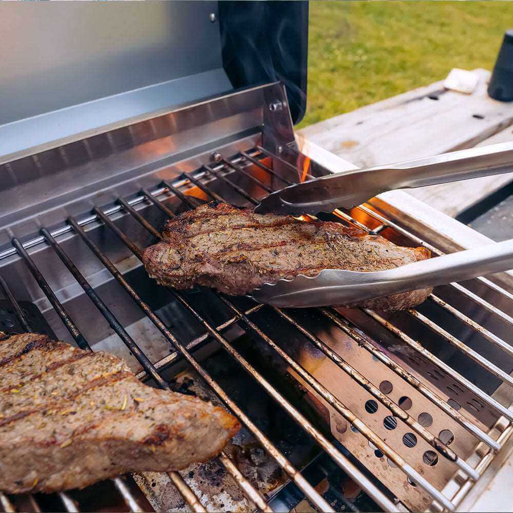 G22 stainless tabletop propane grill grilling steak on stainless grates outdoors on Tampa Home & Garden Store