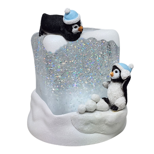 Cube à neige lumineux tourbillonnant avec des pingouins