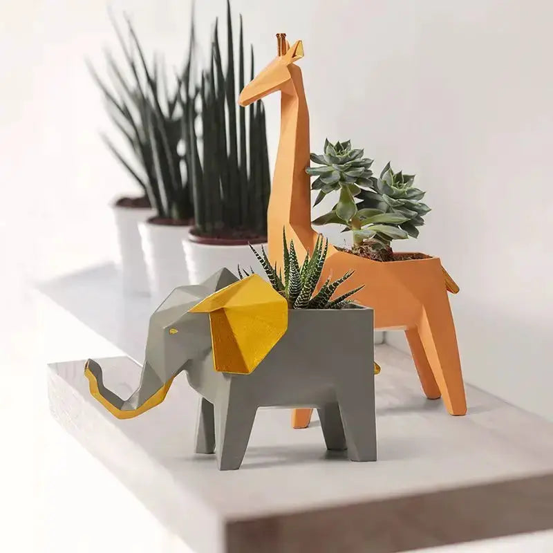 Geometric orange giraffe 3D papercraft planter with succulent, alongside a gray elephant planter on Tampa Home & Garden Store