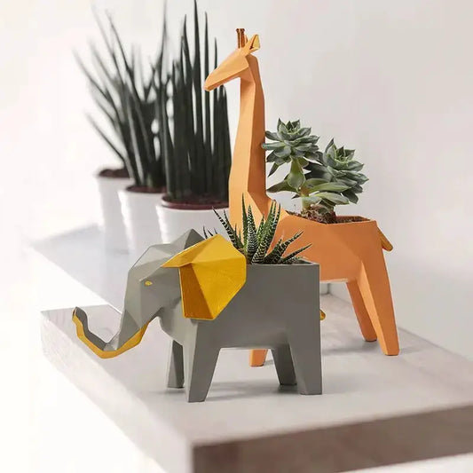 Geometric orange giraffe 3D papercraft planter with succulent, alongside a gray elephant planter on Tampa Home & Garden Store