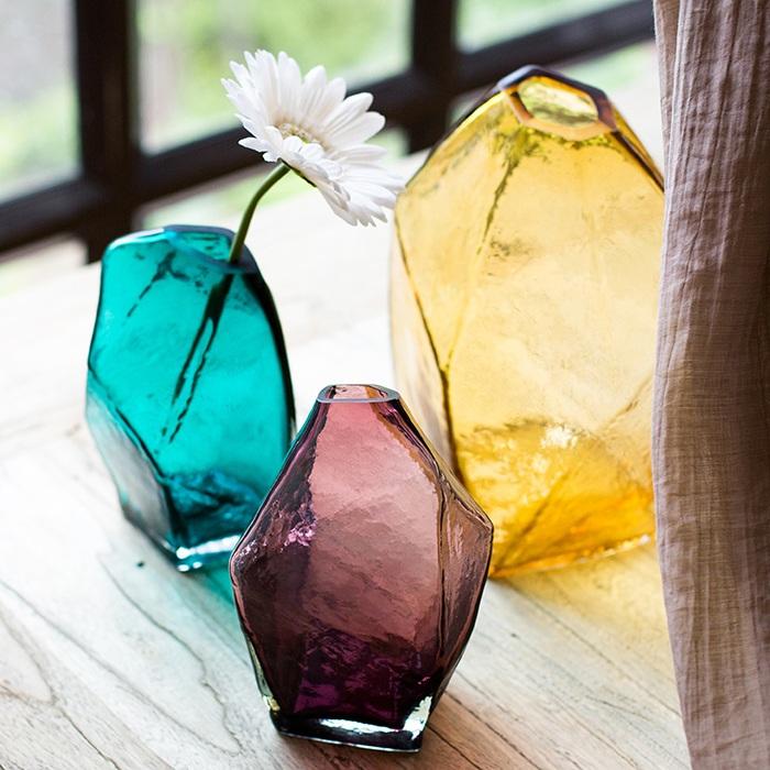 Three hand blown glass vases in teal and purple with a white flower on Tampa Home & Garden Store