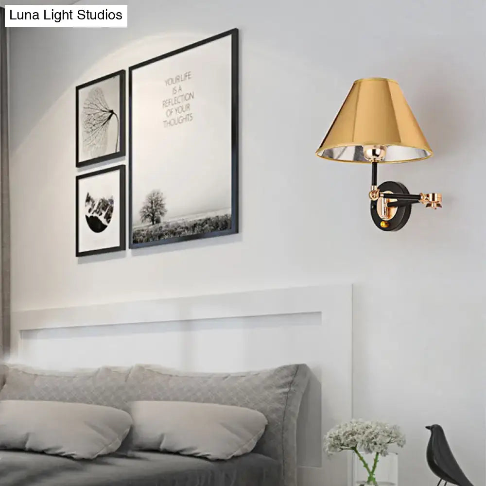 Decorbites gold and black cone wall sconce with brass shade, mounted on a gray bedroom wall on Tampa Home & Garden Store