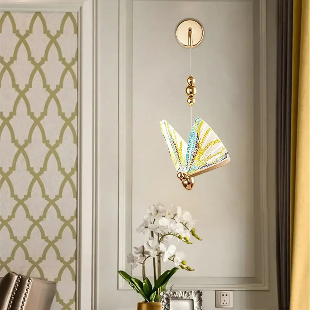 Gold Butterfly LED Wall Light with colorful glass wings, suspended by a gold chain on Tampa Home & Garden Store