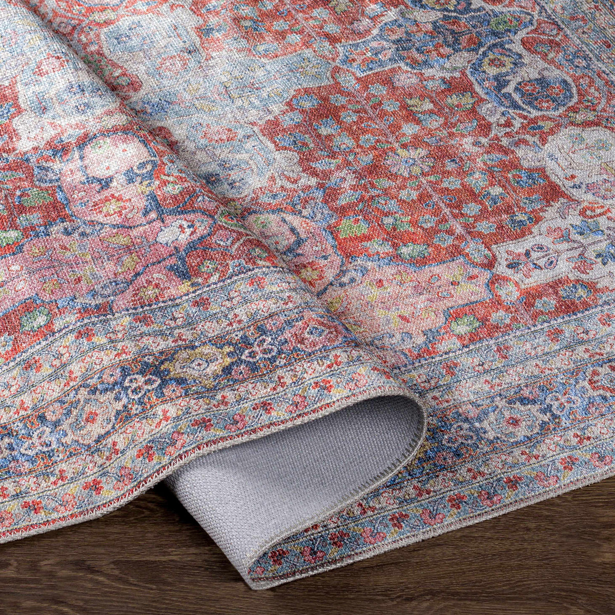 Boutique Rugs Rust Goma Vintage Area Rug red blue beige floral motif, rolled edge view on Tampa Home & Garden Store