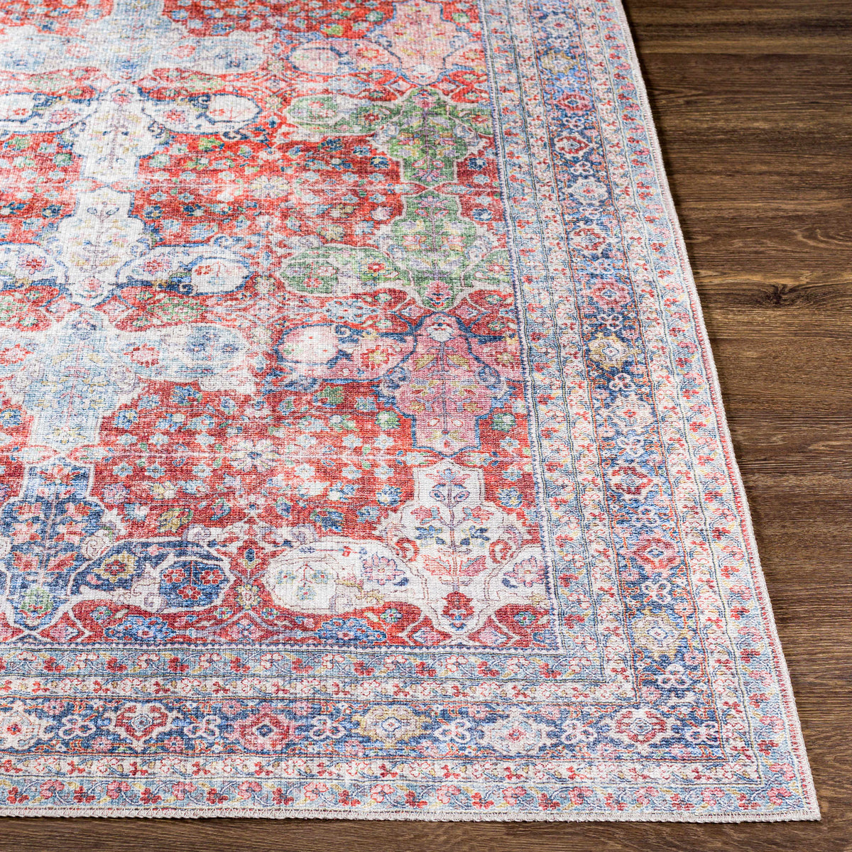 Rust Goma Vintage Area Rug with red blue floral motif and ornate border on wood floor on Tampa Home & Garden Store
