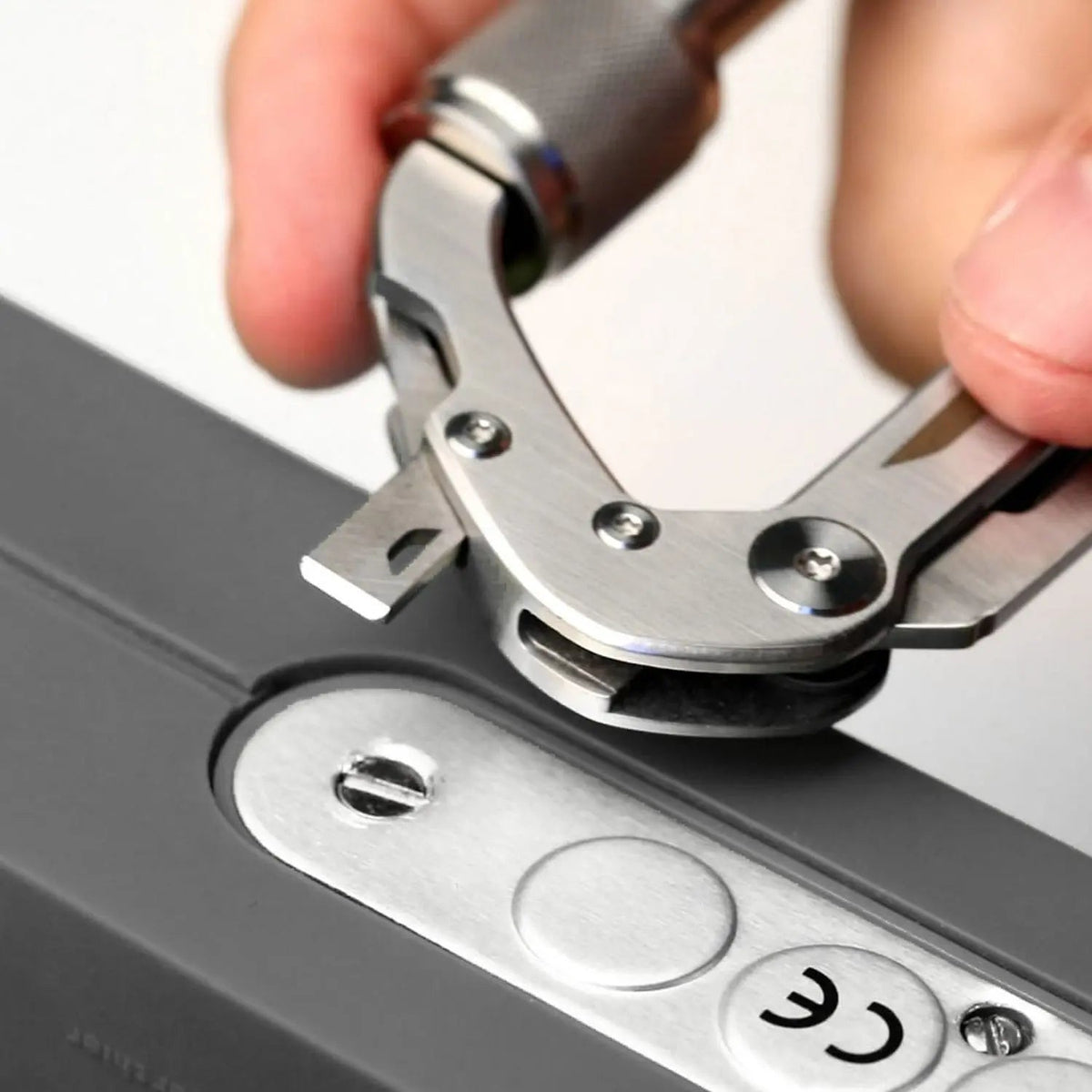 GPCA Carabiner PRO EDC multi-tool clip in stainless steel clipping onto a metal hinge on Tampa Home & Garden Store