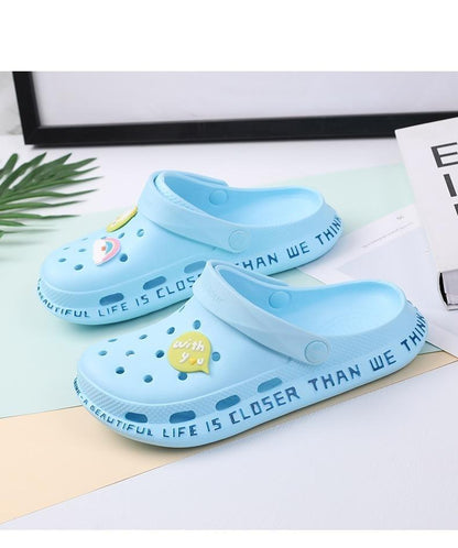Pair of light blue slip-on sandals with vented holes and rear strap yellow heart badge on Tampa Home & Garden Store