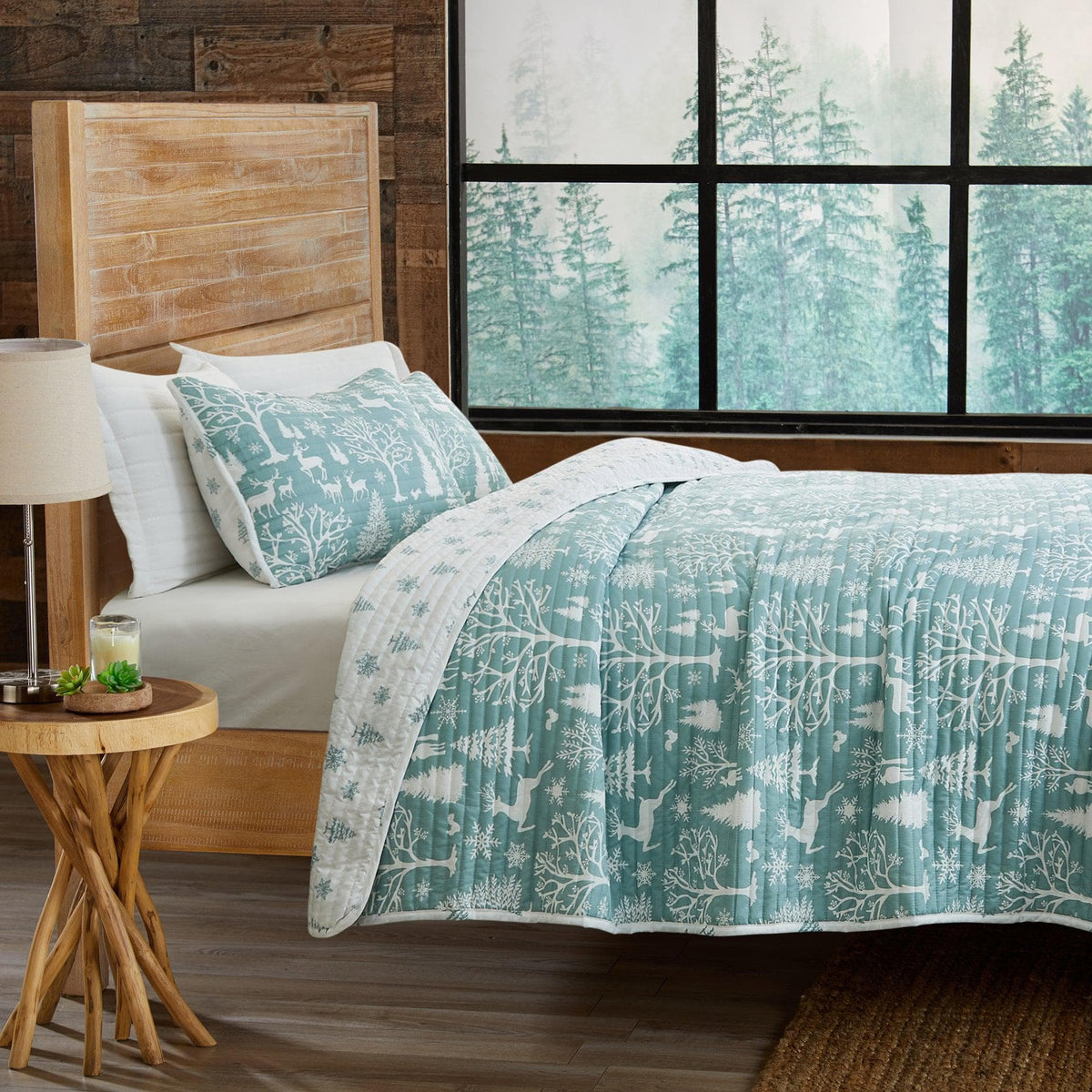 Lodge Woods Quilt by Great Bay Home in teal woodland pattern on a bed on Tampa Home & Garden Store