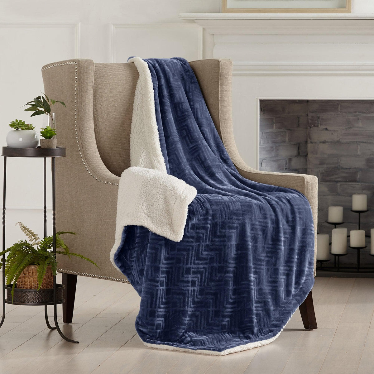 Velvet Plush Sherpa Luxury Bed Blanket in navy blue with sherpa trim draped on beige chair on Tampa Home & Garden Store