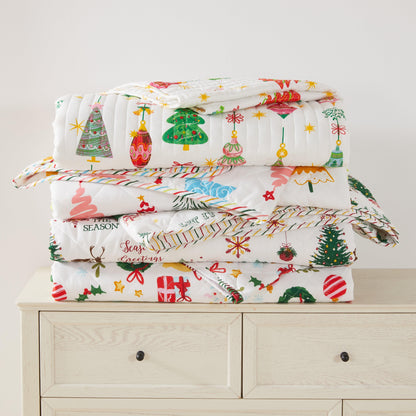 Colorful Holiday Quilt Set by Great Bay Home on a stack of festive quilts with Christmas trees on Tampa Home & Garden Store