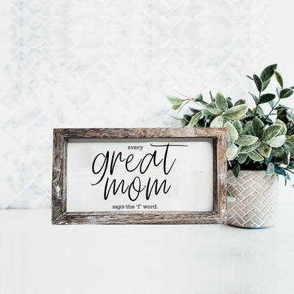 Great Mom sign in a weathered wooden frame with white panel and black script text beside a plant on Tampa Home & Garden Store