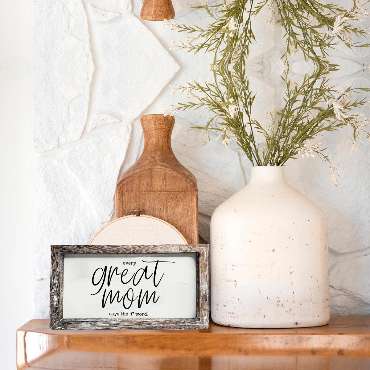 Great Mom sign in distressed wood frame with rustic decor beside a white vase of greenery on Tampa Home & Garden Store