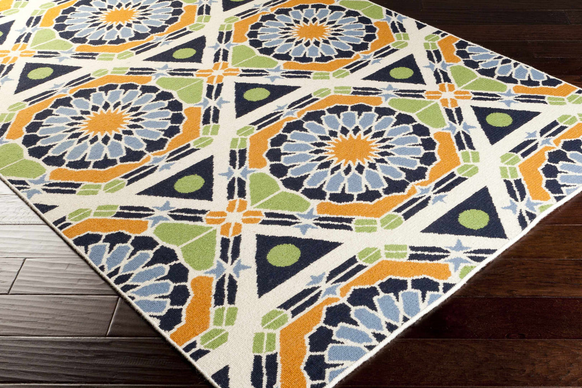Greenough Area Rug by Boutique Rugs with navy geometric medallions and orange accents on cream on Tampa Home & Garden Store