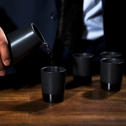 Four Black Stoneware Sake Tumblers and Carafe