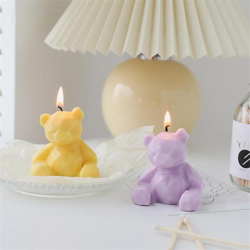 Two bear-shaped scented candles in yellow and lavender with lit wicks, teddy bear decor on Tampa Home & Garden Store