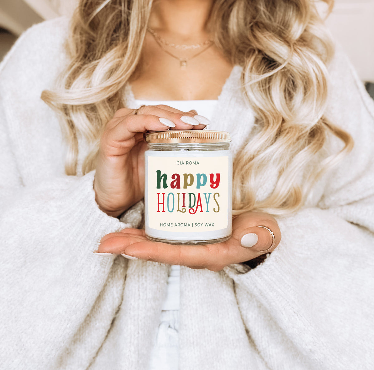 Happy Holidays candle by Gia Roma, soy wax in a clear jar with a rose-gold lid, held by a woman on Tampa Home & Garden Store