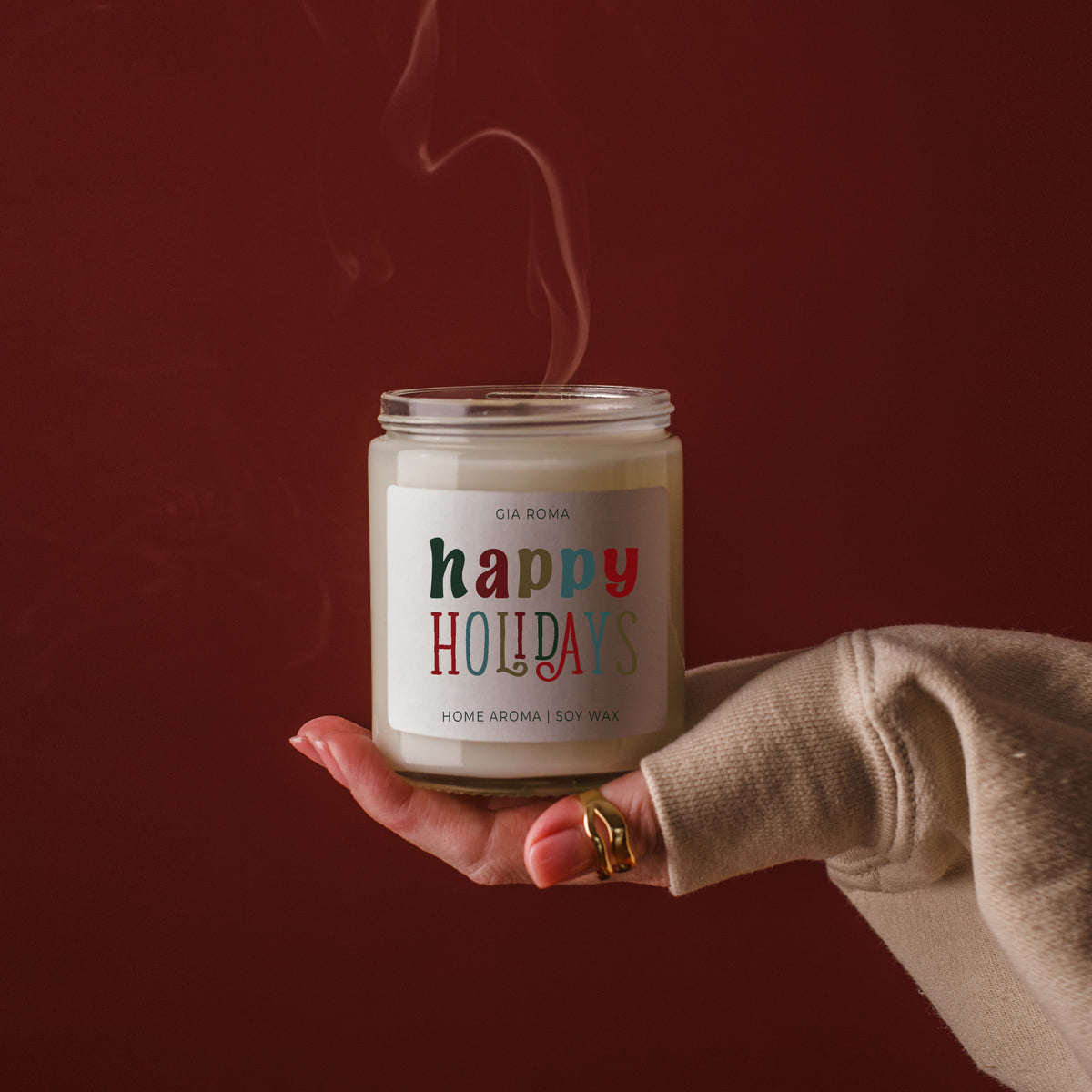 Gia Roma Happy Holiday Candle, soy wax in glass jar with colorful HOLIDAYS label held in hand on Tampa Home & Garden Store