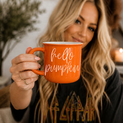 Hello Pumpkin coffee mug by Gia Roma, orange ceramic mug held by a woman on Tampa Home & Garden Store