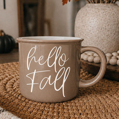 Hello Fall coffee mug taupe ceramic with white cursive hello fall on woven placemat on Tampa Home & Garden Store