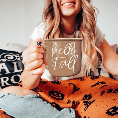 Gia Roma Hello Fall coffee mug in taupe with white script, held by a smiling woman on Tampa Home & Garden Store
