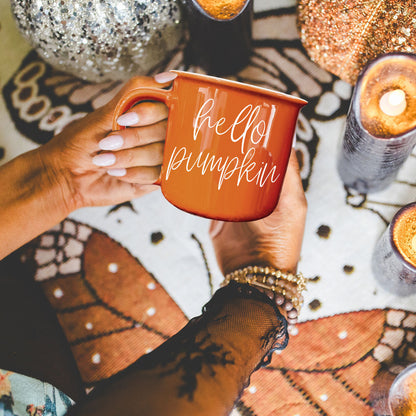 Hello Pumpkin mug by Gia Roma in orange ceramic, held by hands with white nails on Tampa Home & Garden Store