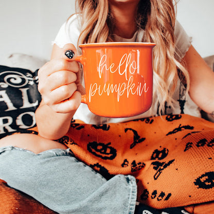 Hello Pumpkin coffee mug orange ceramic with white cursive text, held by a person on Tampa Home & Garden Store