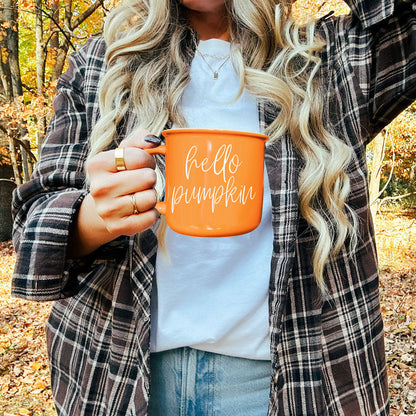 Hello Pumpkin coffee mug, orange ceramic by Gia Roma with white script, held outdoors in fall on Tampa Home & Garden Store