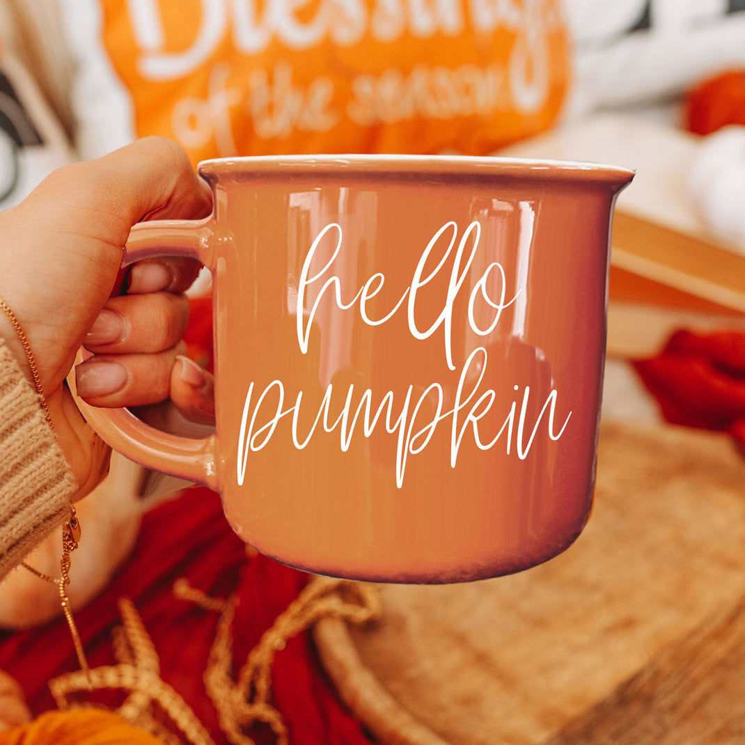 Hello Pumpkin coffee mug by Gia Roma, orange ceramic with white script held in hand on Tampa Home & Garden Store
