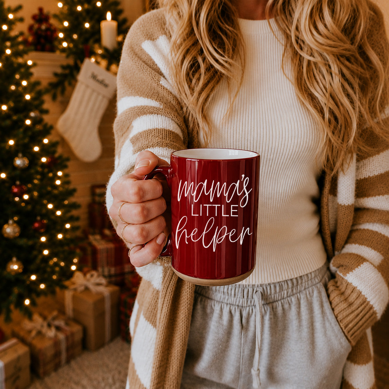 Mama's Little Helper mug, red ceramic with white script held in a cozy Christmas setting on Tampa Home & Garden Store