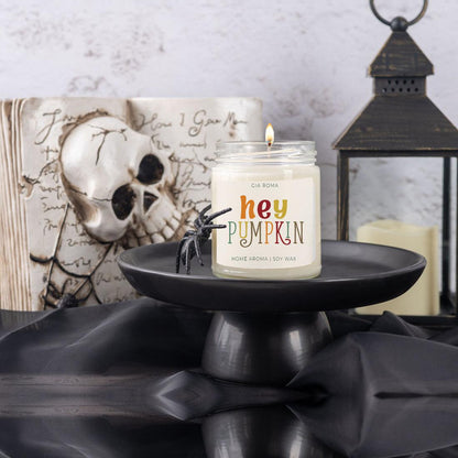Baked Pumpkin Candle by Gia Roma in a clear jar on a black pedestal with Halloween decor on Tampa Home & Garden Store