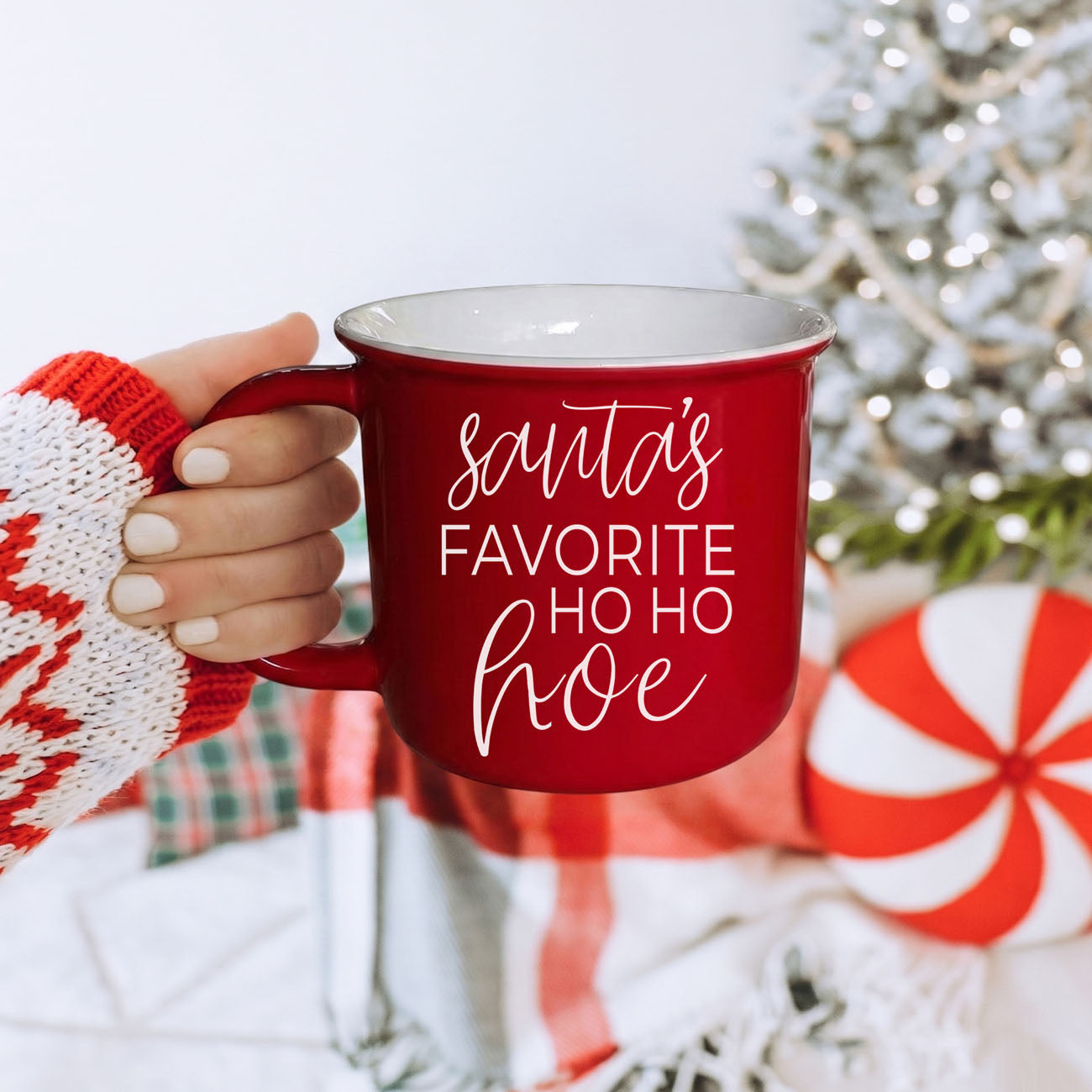 Ho Ho Hoe mug red with white script, held by knit sleeve amid holiday decor on Tampa Home & Garden Store