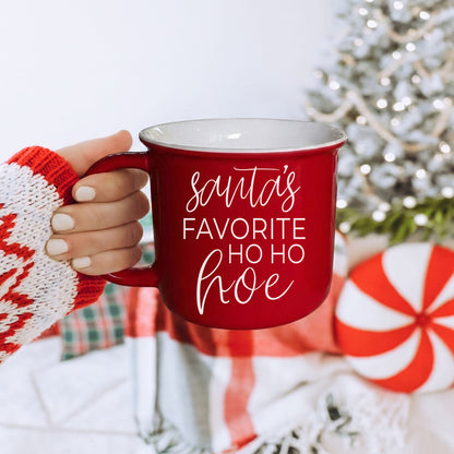 Ho Ho Hoe mug red with white script, held by knit sleeve amid holiday decor on Tampa Home & Garden Store