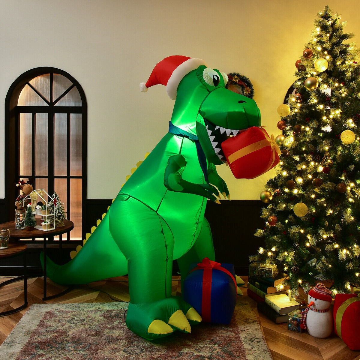 6 Feet Christmas Inflatable Dinosaur DirectDeals with Santa hat beside a lit Christmas tree indoors on Tampa Home & Garden Store
