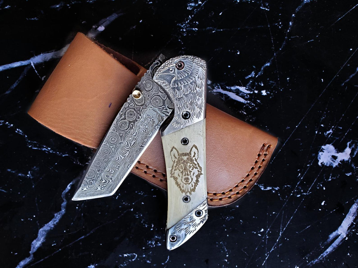 Pair of Titan American Eagle raindrop Damascus folding knives with wolf-on-bone handles on Tampa Home & Garden Store