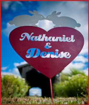 Custom heart metal garden sign with Nathaniel & Denise in white script on pink heart stake on Tampa Home & Garden Store