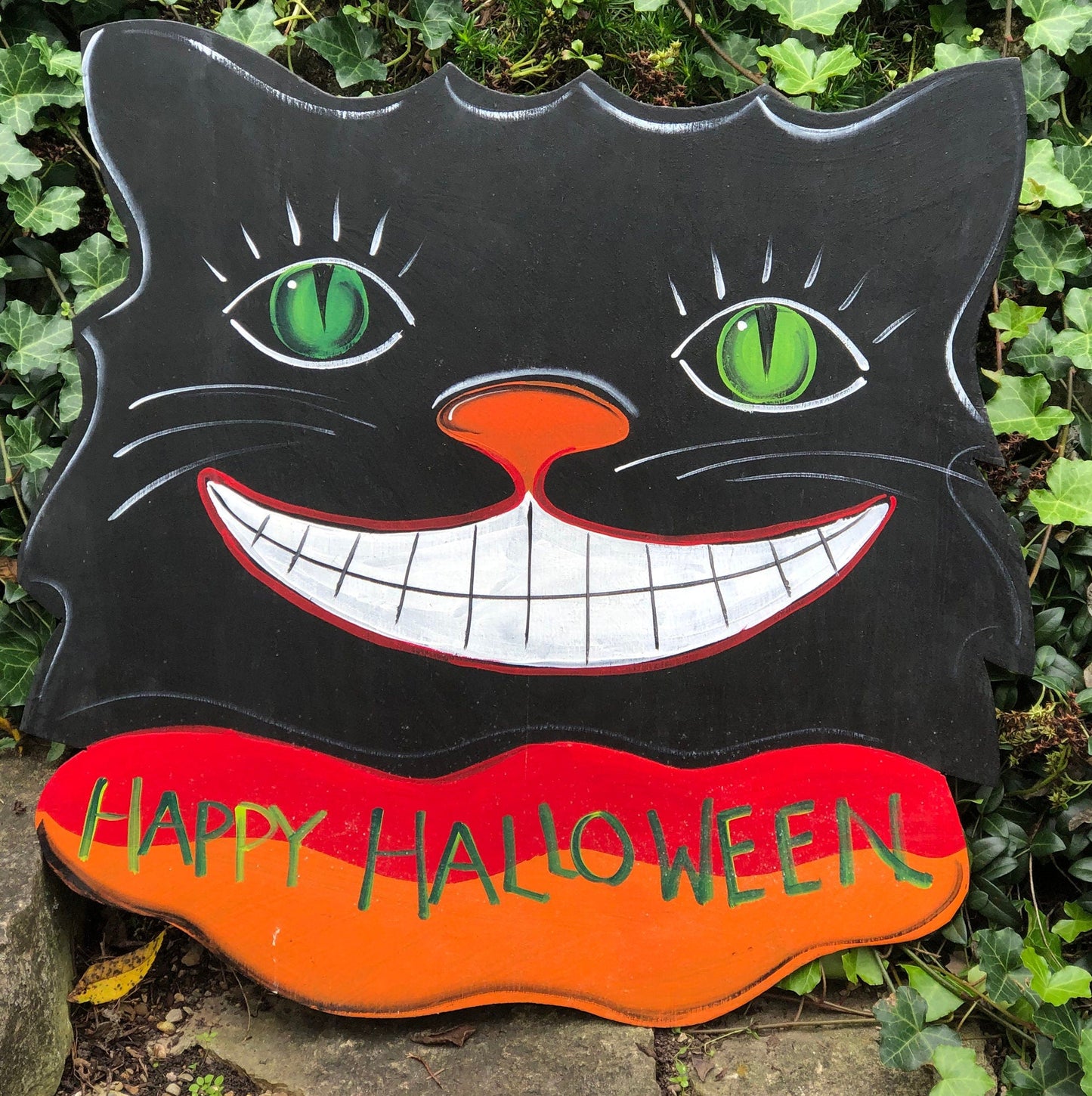 Sign on Wooden Black Cat Cutout Reading Happy Halloween.