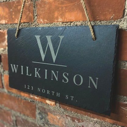 Personalized slate address sign with last name Wilkinson, white lettering, rope hanger on brick on Tampa Home & Garden Store