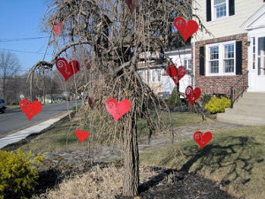 Hanging Heart Tree Ornaments Set of 12 red heart decorations on a bare tree in a suburban yard on Tampa Home & Garden Store