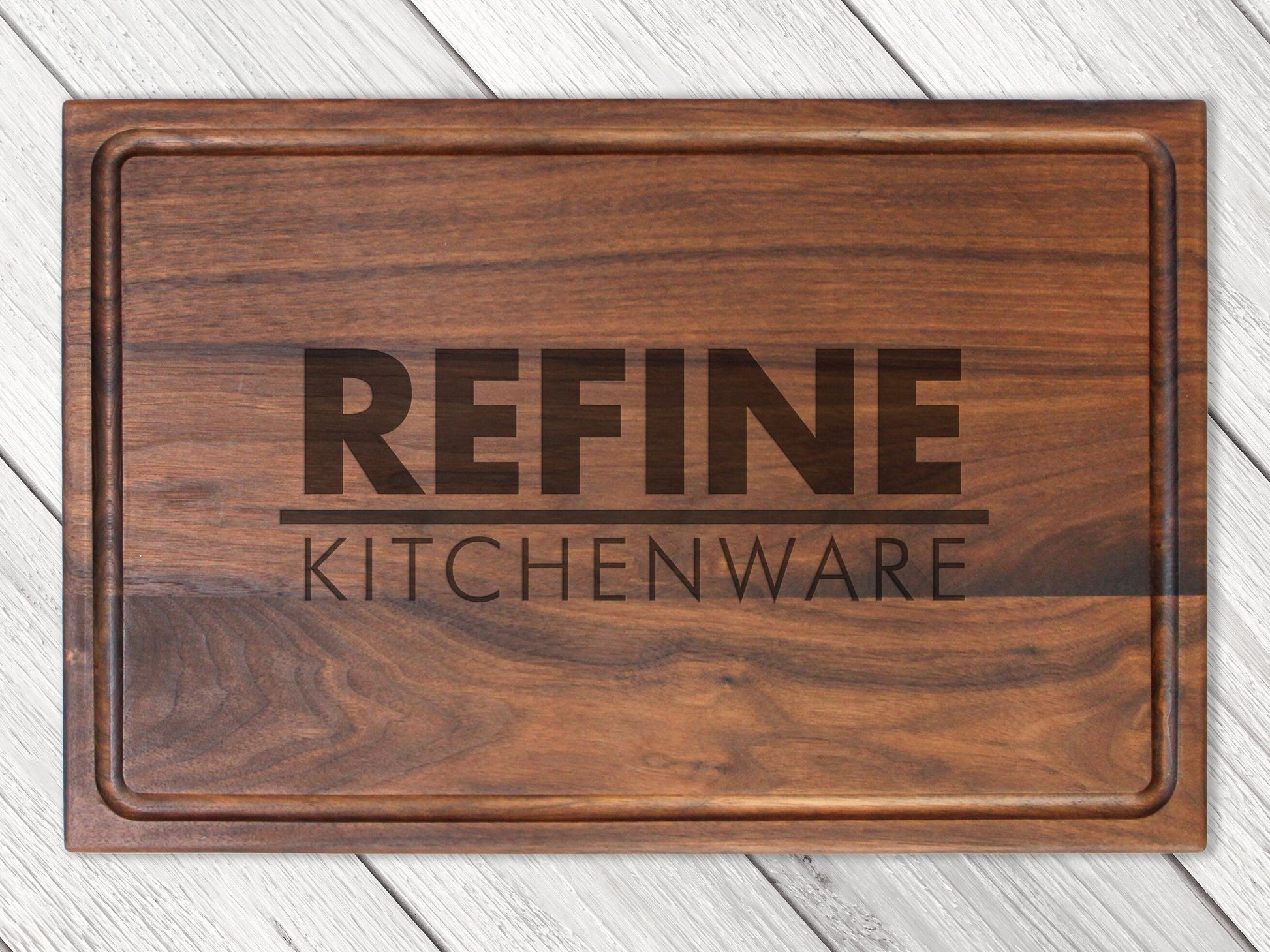 Custom logo cutting board in dark walnut wood with engraved REFINE KITCHENWARE branding on Tampa Home & Garden Store