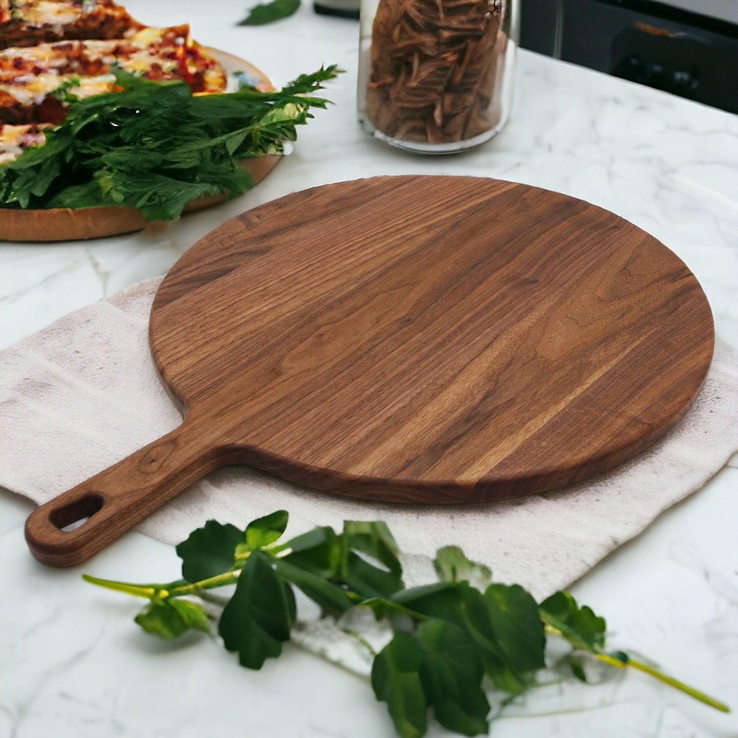 Walnut paddle cutting board with handle on marble counter with parsley garnish on Tampa Home & Garden Store