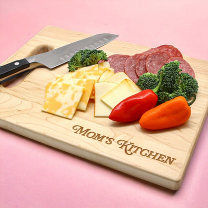 Personalized Mother's Day Cutting Board with engraved MOM'S KITCHEN, assorted cheese, salami, broccoli and peppers on Tampa Home & Garden Store