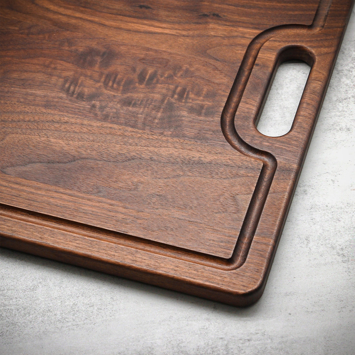 Extra Large Custom Engraved Walnut Cutting Board with built-in handle and rich wood grain on Tampa Home & Garden Store