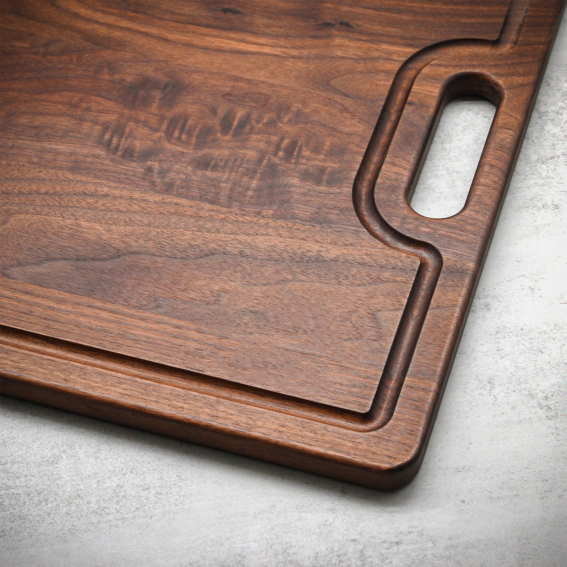 Extra Large Custom Engraved Walnut Cutting Board with built-in handle and rich wood grain on Tampa Home & Garden Store