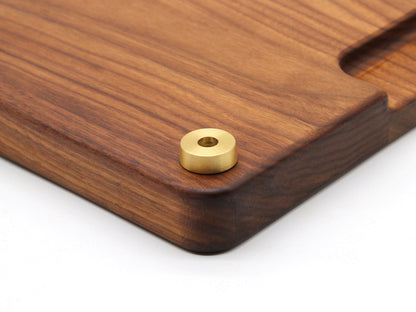 Premium brass cutting board feet with 1-inch diameter brass hardware on a wooden cutting board on Tampa Home & Garden Store