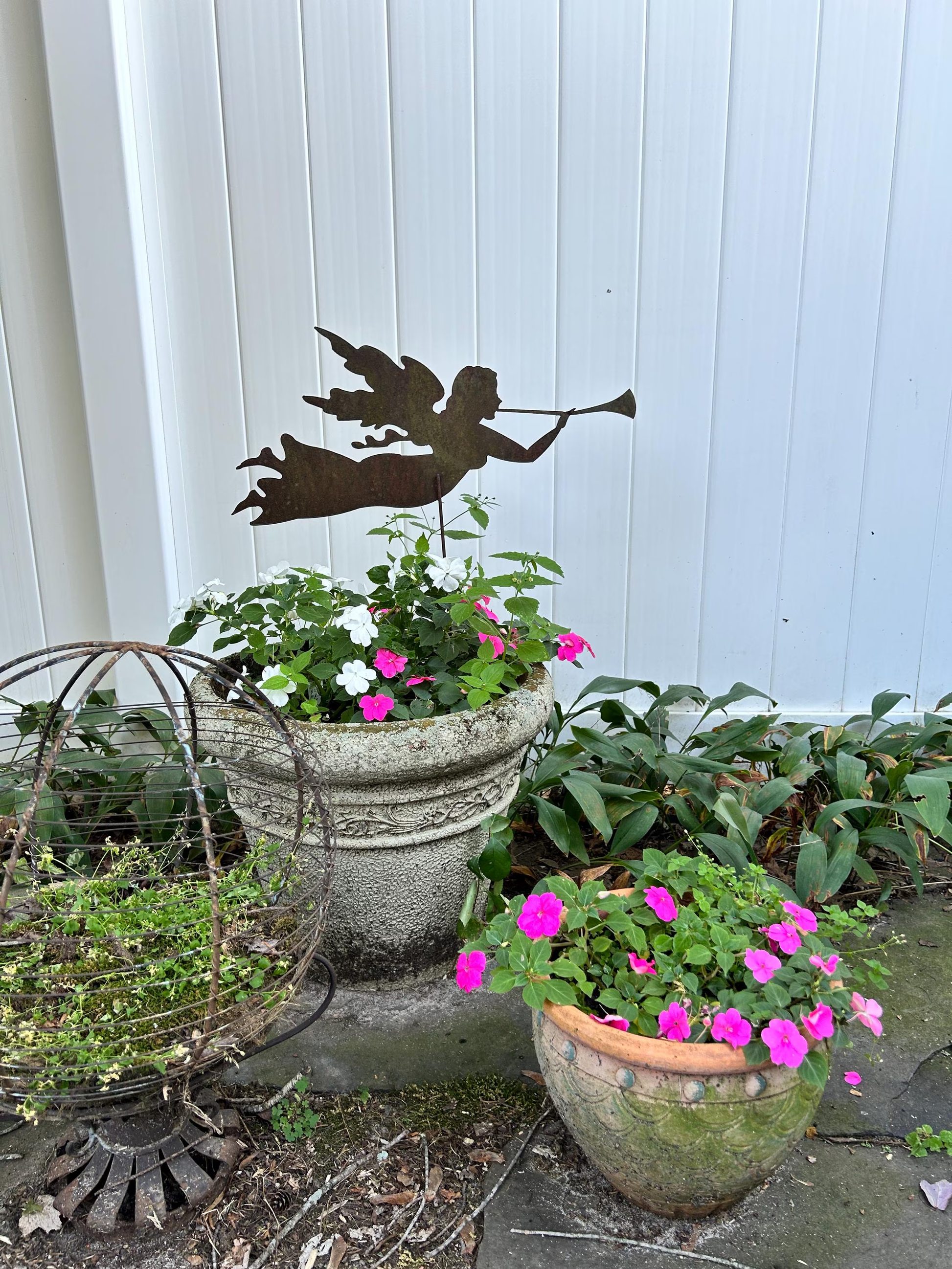 Angel garden stake silhouette in dark metal by Rustica Ornamentals, with planter and flowers on Tampa Home & Garden Store
