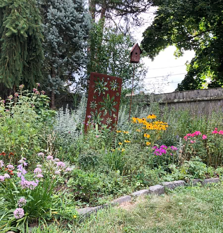 Rust-colored steel outdoor privacy screen panel with floral cutouts by Rustica Ornamentals on Tampa Home & Garden Store