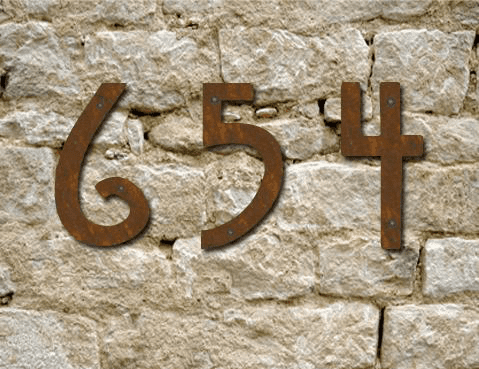 Mission Style metal house numbers set of 5 in rust brown finish mounted on a stone wall on Tampa Home & Garden Store
