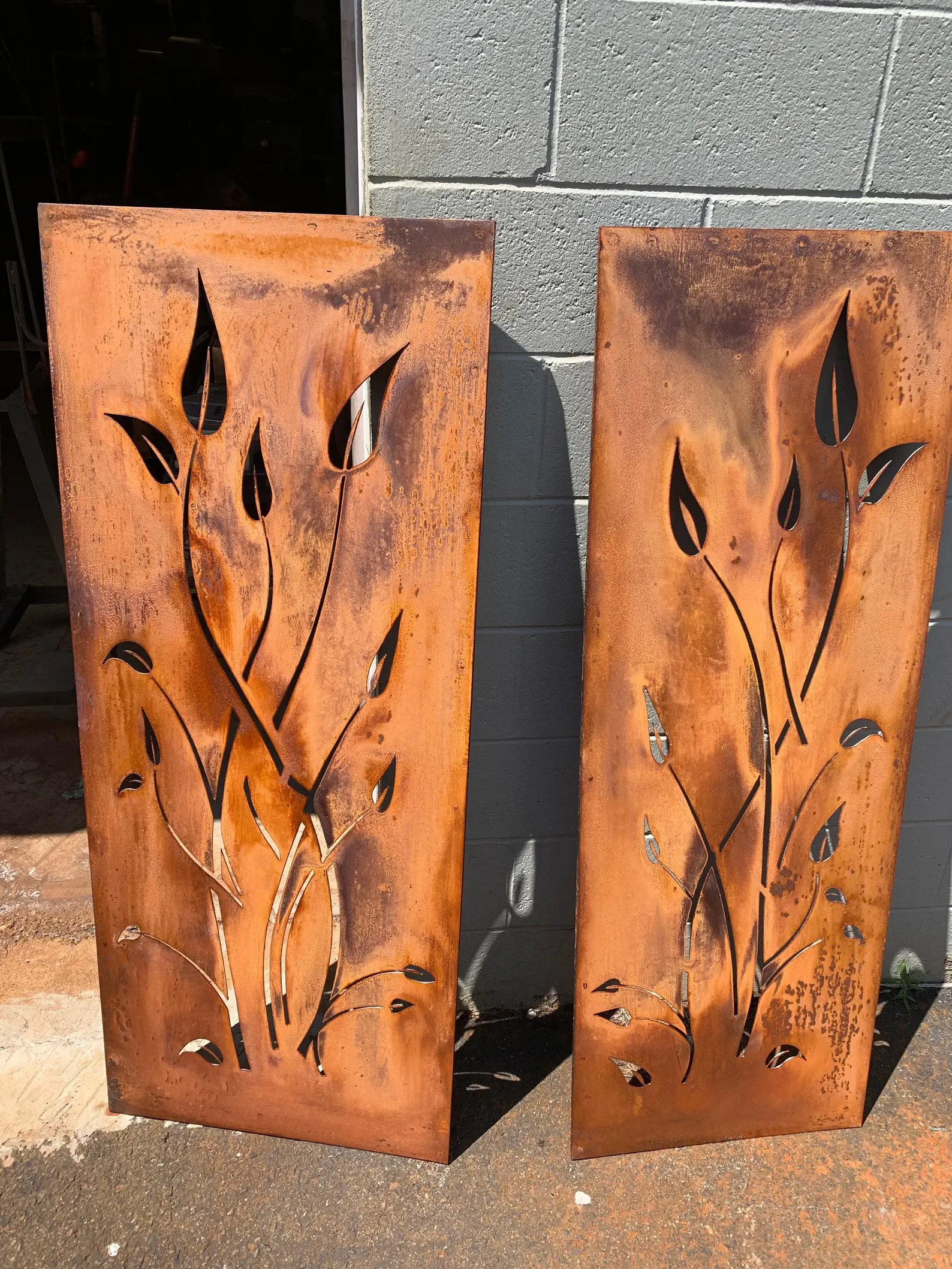 Outdoor metal privacy panels in rusted steel with leaf cutouts, two sizes 24x60 and 24x72 on Tampa Home & Garden Store