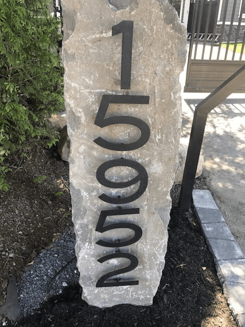 Metal house numbers 19502 in black on a rough outdoor stone slab on Tampa Home & Garden Store