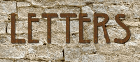 Mission Style metal house letters set on a textured brown stone wall on Tampa Home & Garden Store